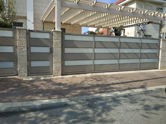 שער מתרומם חשמלי לחניה כולל עיצוב מותאם גם לשער וגדר. צילום: ערן