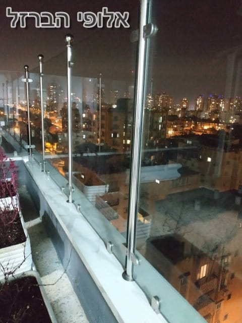 מעקות זכוכית עם עמודים מנירוסטה במרפסת בדירה בקומה 9. צילום: ערן